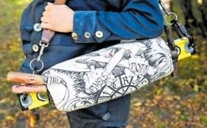 B&uuml;ndel mit Handerwerksgegenst&auml;nden wird von einer Person getragen. Man sieht nur die Schulter und die Hand.