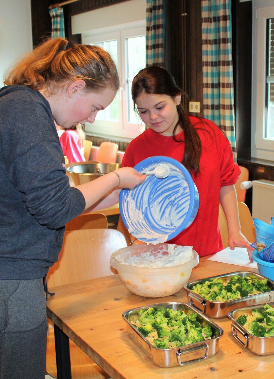 Zwei Kids bereiten verschiedenen vegetarische Gerichte zu