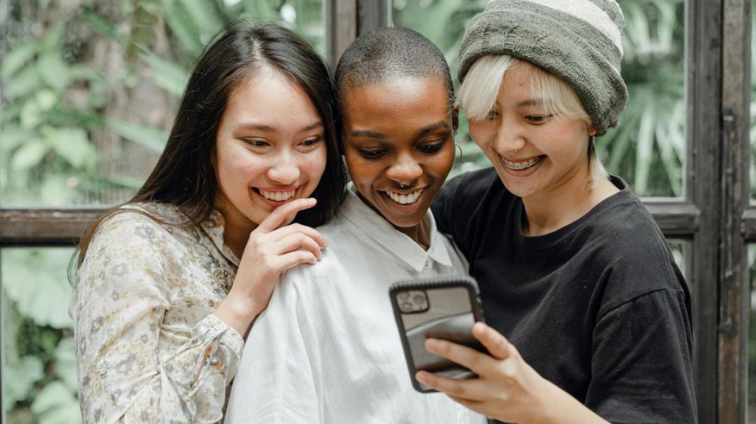 Junge Menschen schauen gemeinsam auf ein Smartphone