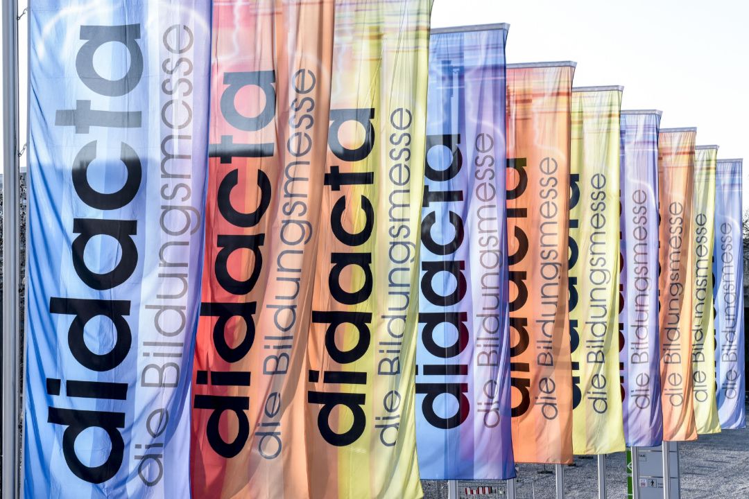 zu sehen sind 11 Flaggen in unterschiedlichen Farben mit dem Aufdruck "didacta die Bildungsmesse"