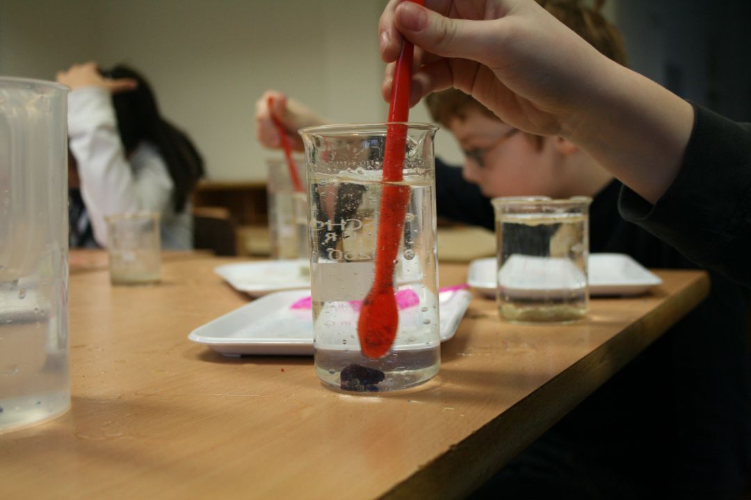 In einem Reagenzglas wird mit Hilfe eines Spatels Wasser mit &Ouml;l verr&uuml;hrt.