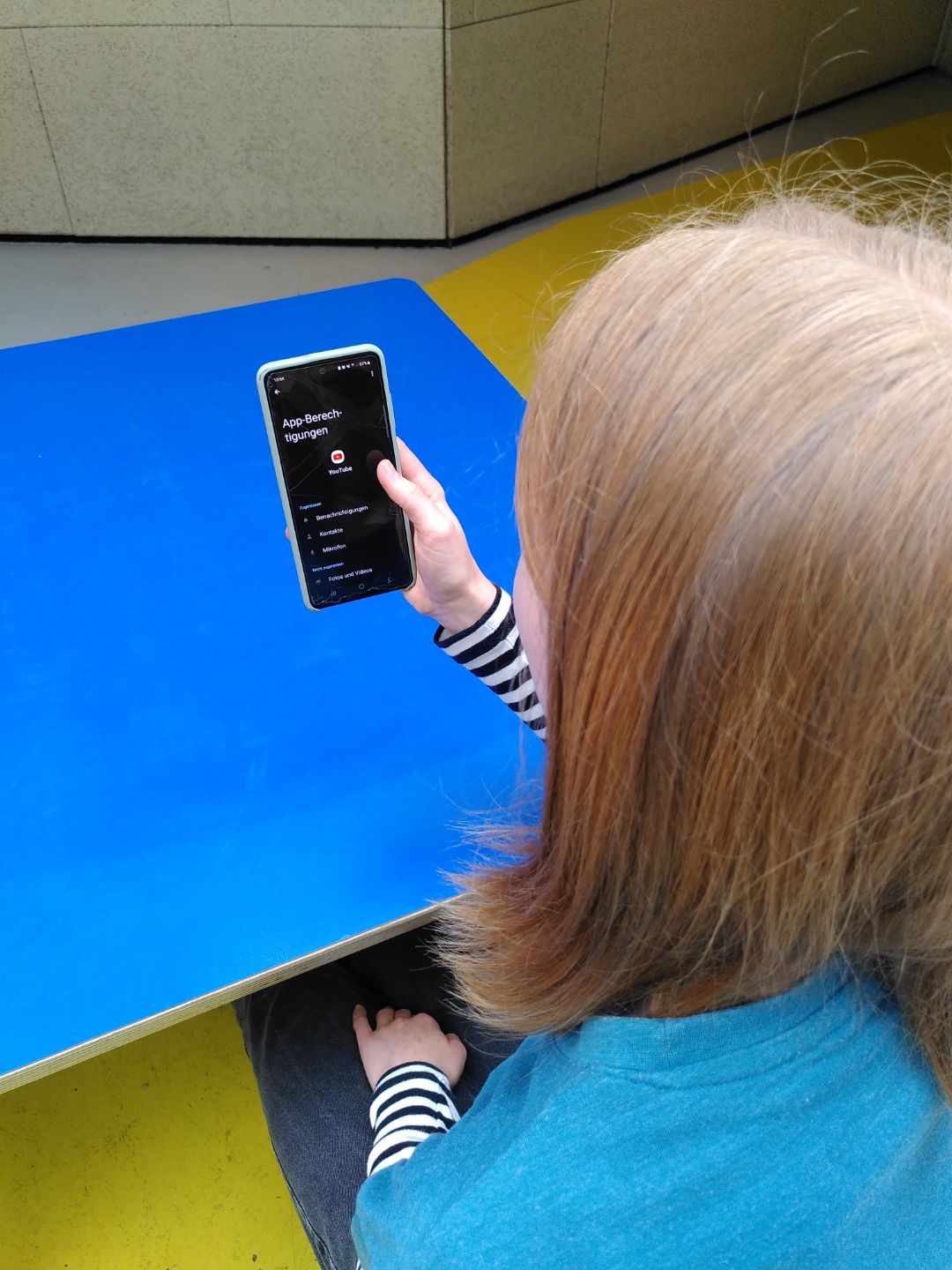 Sch&uuml;lerin schaut auf ihr Handy