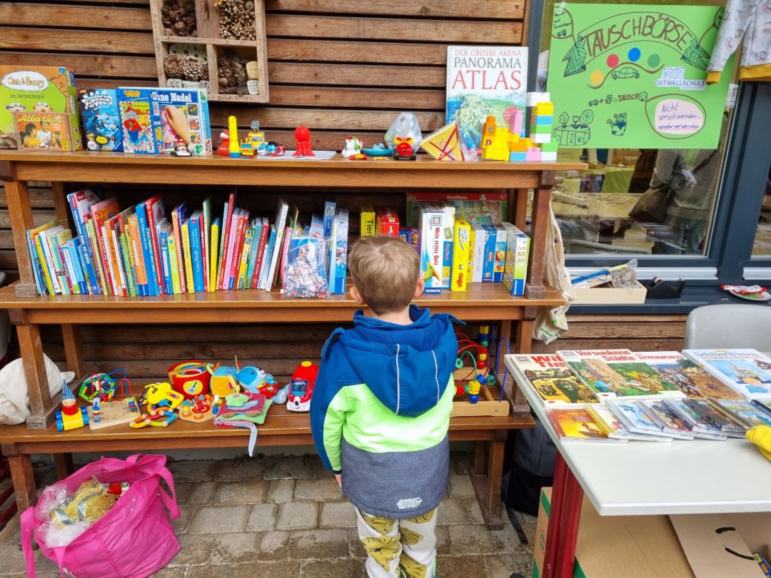 Ein Junge steht suchend vor einem Regal mit gebrauchten B&uuml;chern