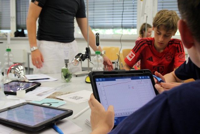 Jugendliche sitzen an Tablets.