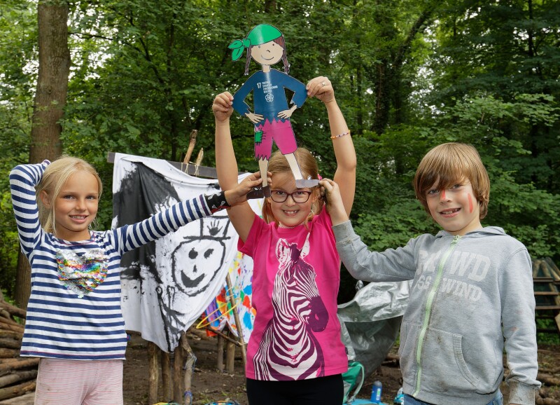 Drei Kinder zeigen einen gebastelten Piraten der Ferienwoche 