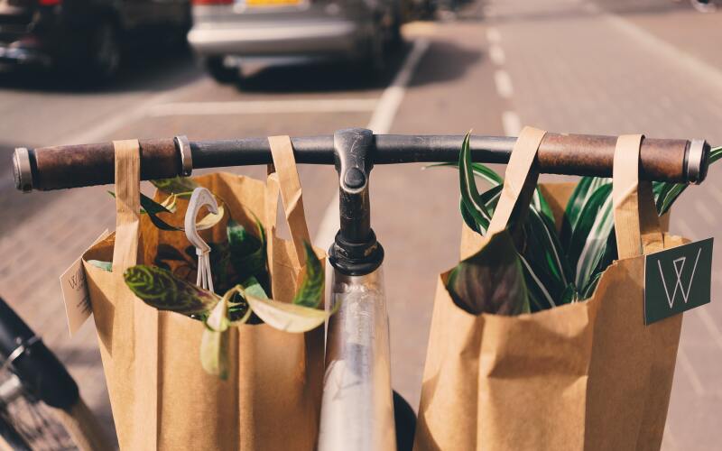 Ein Einkauf wird in Papiertüten verpackt auf einem Fahrrad transportiert.