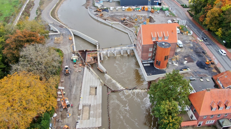 Ein Luftbild zeigt eine Baustelle am Fluss Berkel. Zu sehen sind rechts im Bild ein Wehr, das umgebaut wird und links daneben der Zugang zu einer neuangelegten Fischaufstiegsanlage.