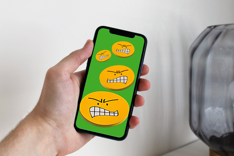 Ein Smartphone zeigt böse Smileys.